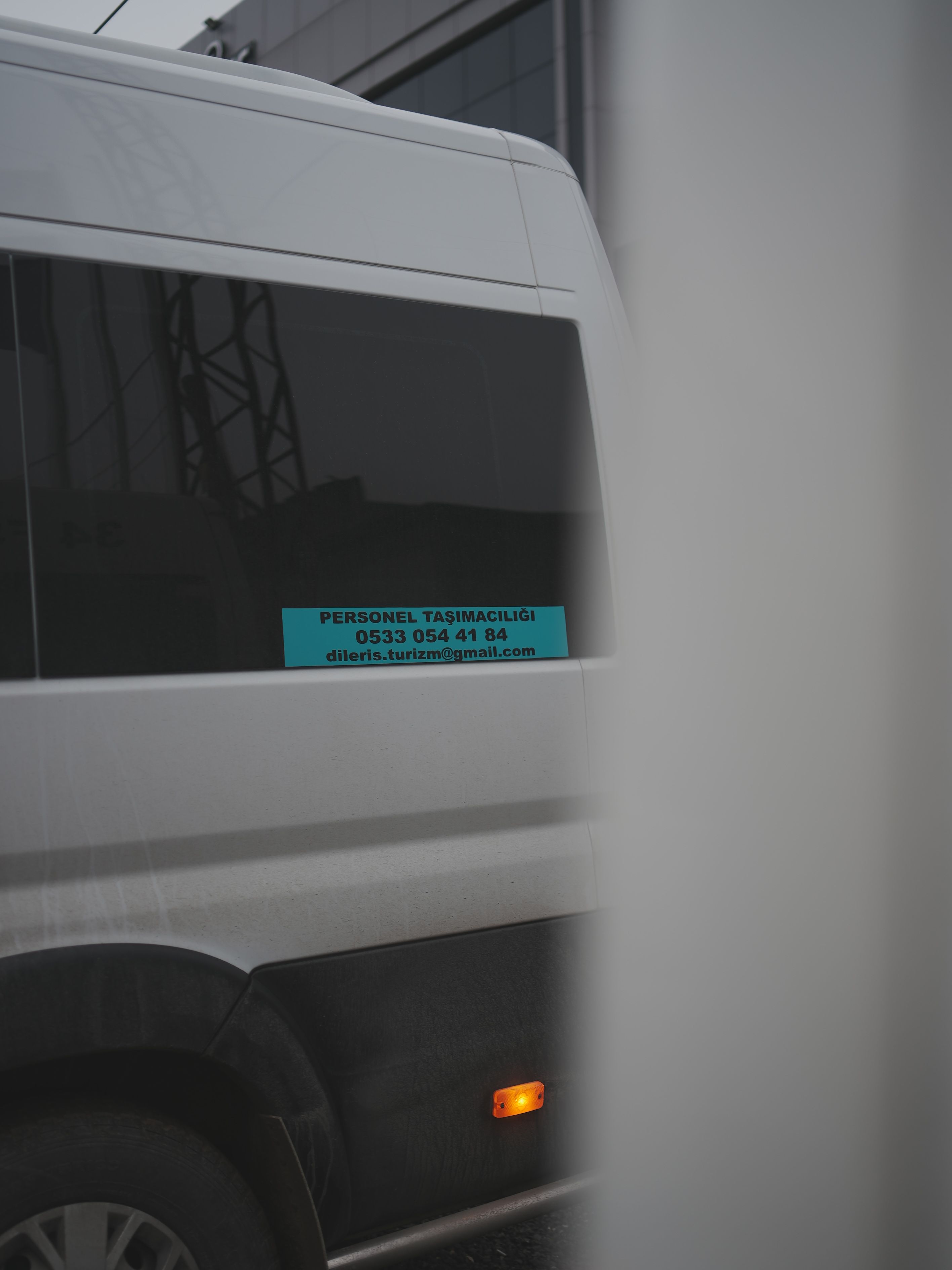 Servis aracının camındaki Diler Tur Personel Taşımacılığı iletişim etiketi